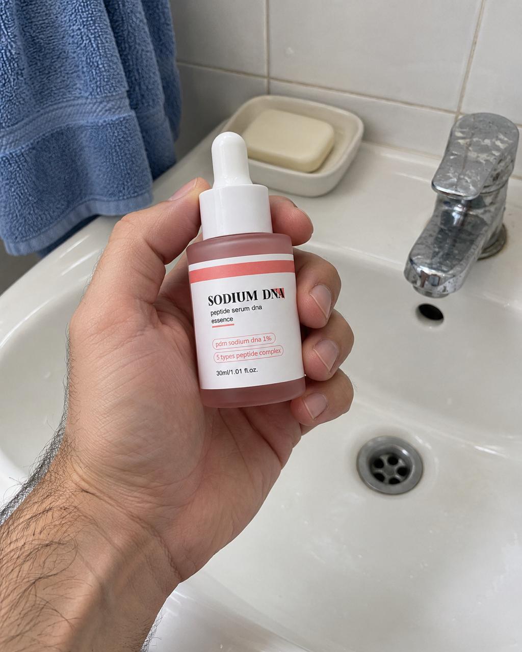 Salmora serum held beside a bathroom sink